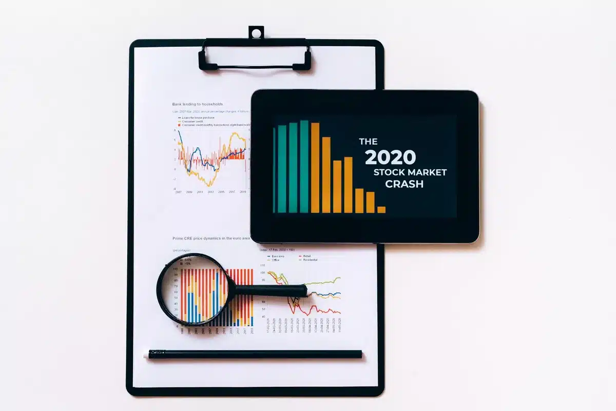 A glowing screen displaying stock market data in downward motion, red candlestick charts steeply declining, a silhouette of hands raised in concern before the screen, economic anxiety palpable.