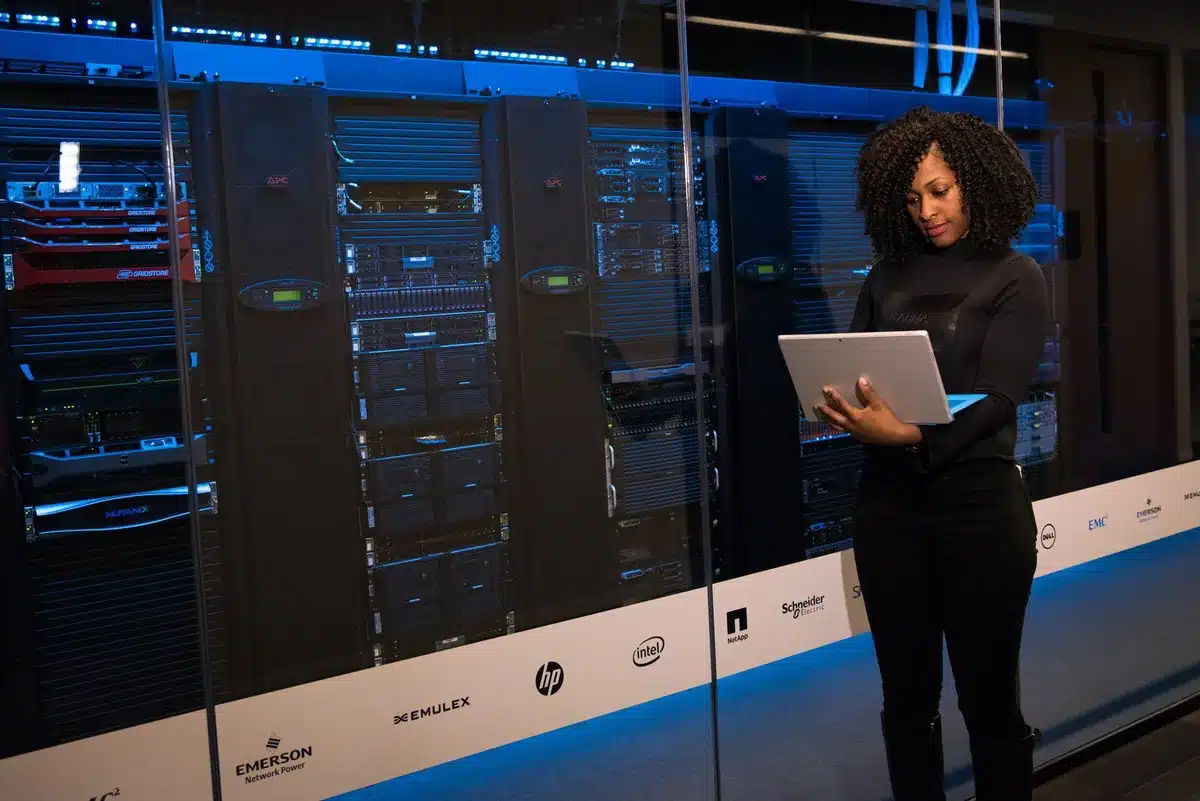 Semiconductor manufacturing floor with rows of server racks and glowing indicators, representing data center infrastructure deployment
