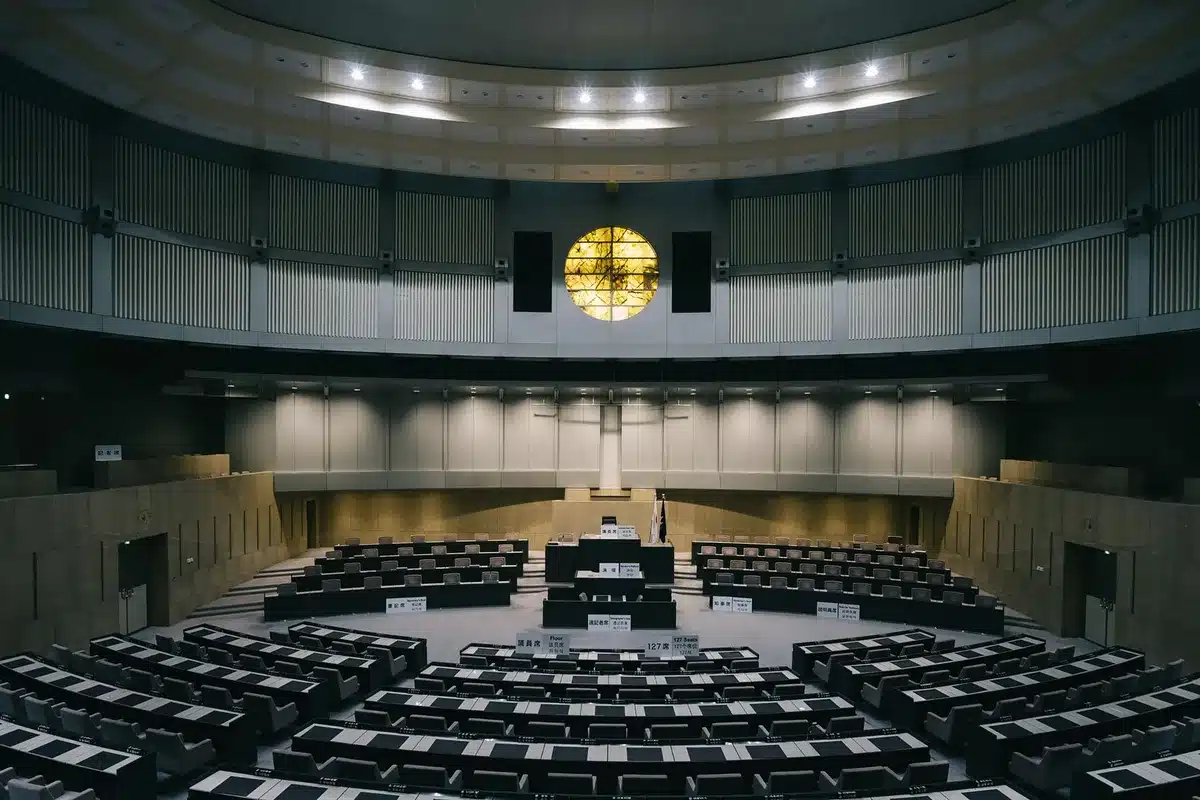 A podium with a microphone in an empty New Hampshire town hall, morning light streaming through windows, ready for a political event