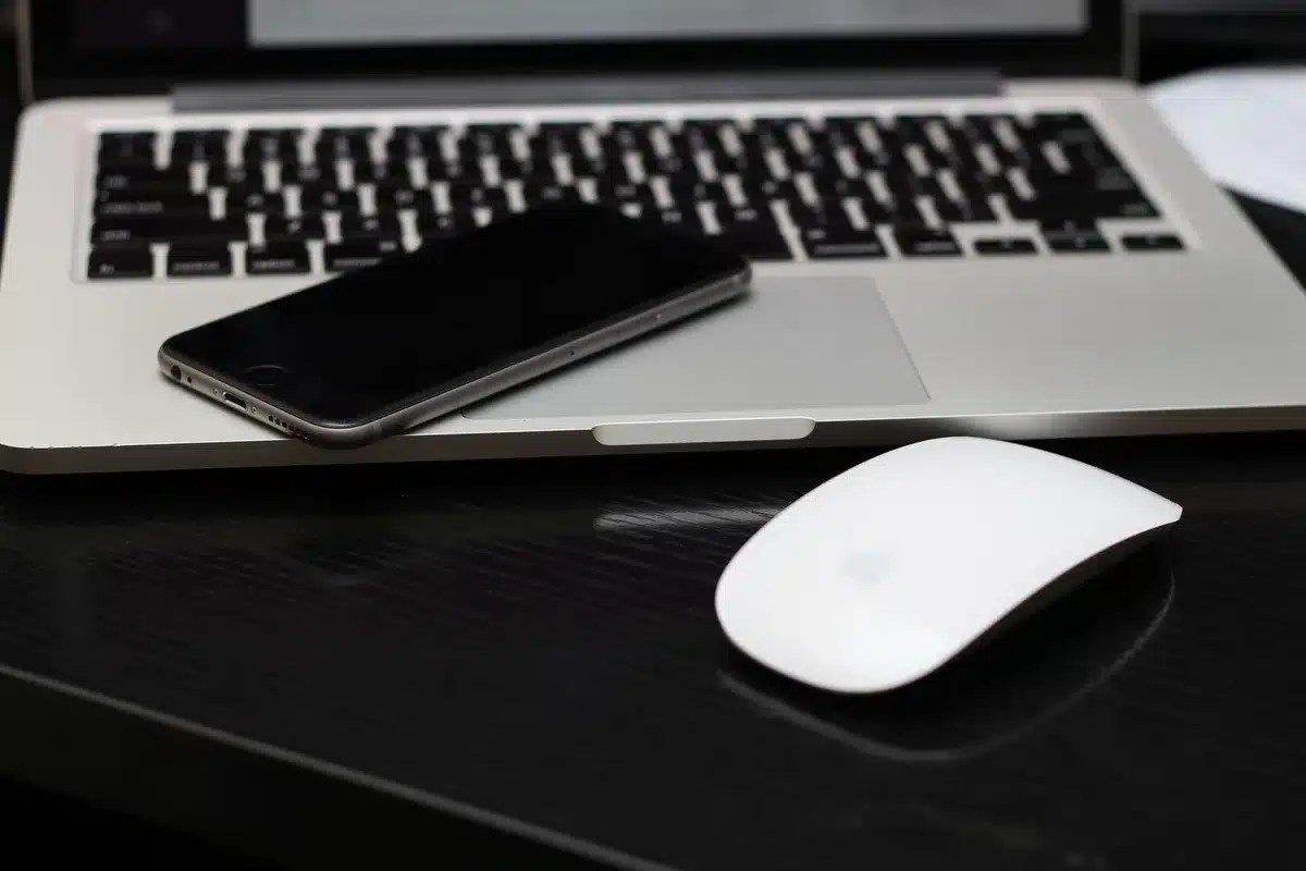 A modern Apple product design studio with sleek prototypes on illuminated display tables, technical drawings on walls, and design tools scattered across workbenches—no people visible, emphasizing the engineering focus.