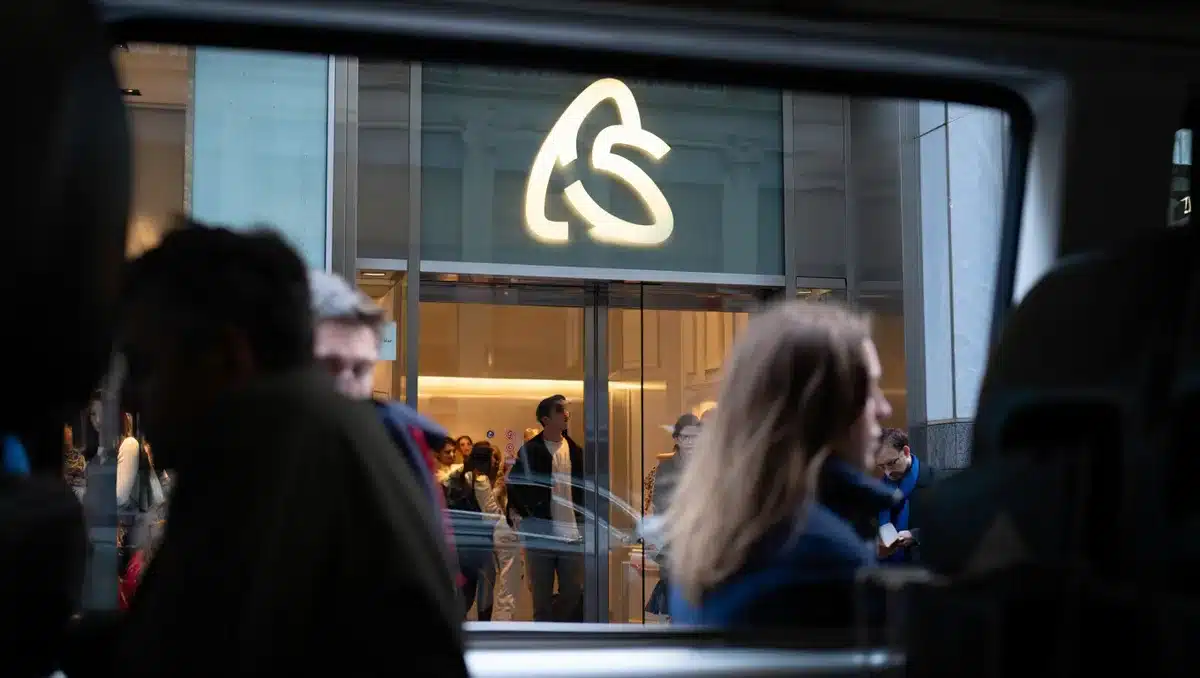 Apple retail storefront with illuminated logo, customers visible through windows, modern glass architecture | Apple store exterior