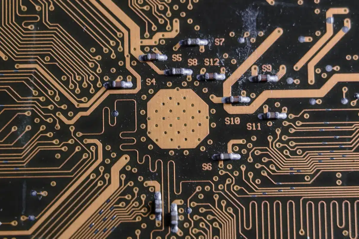 A close-up of a semiconductor wafer under industrial lighting, showing intricate circuitry patterns, symbolizing ARM's chip design technology and market position