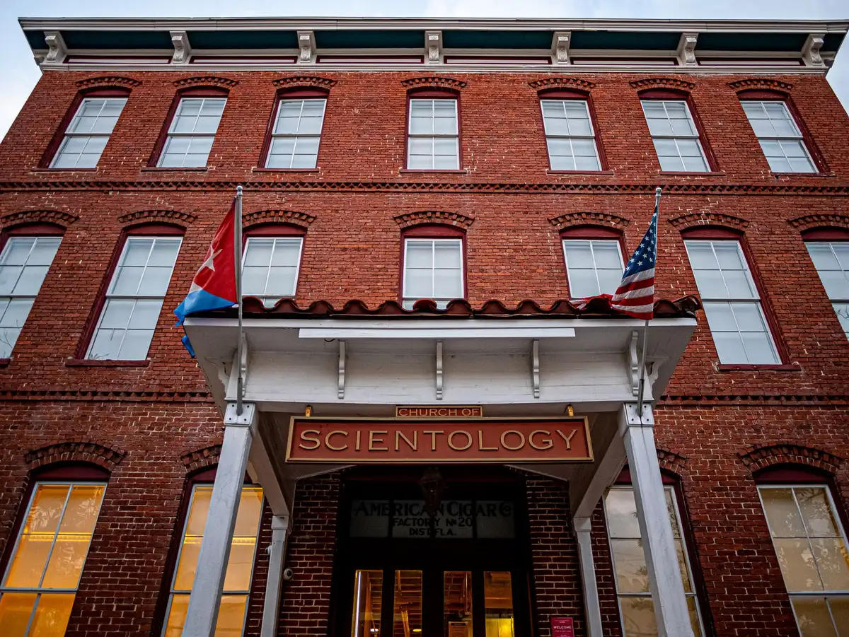 Government office building with American flag at entrance, daytime, formal institutional setting