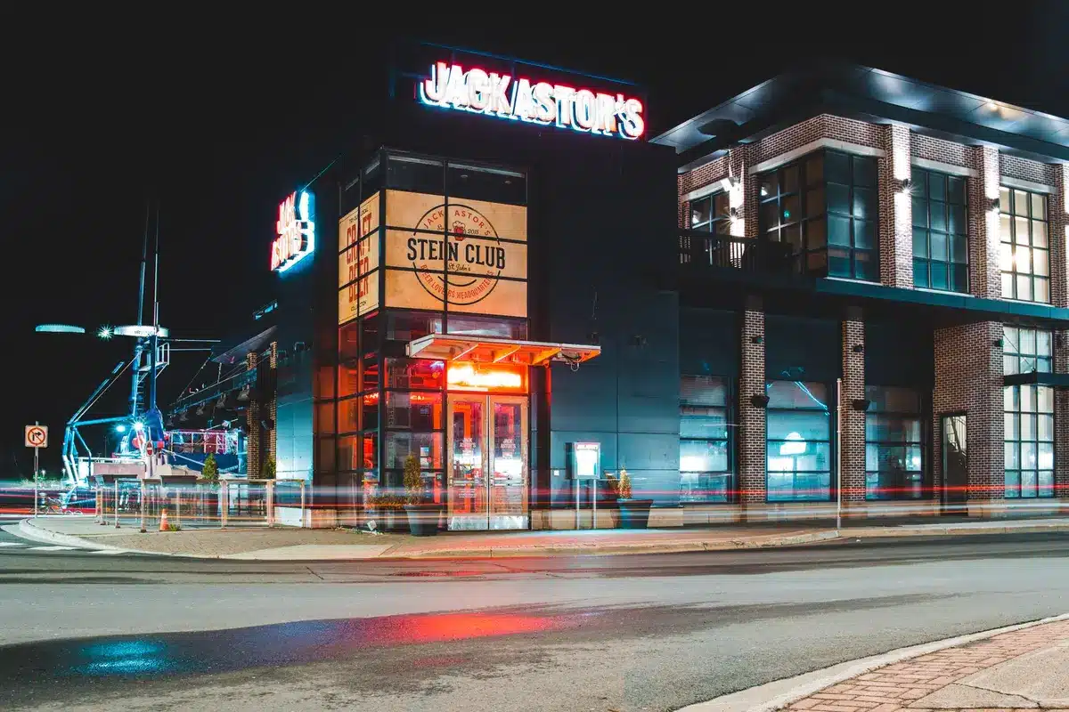 A Cracker Barrel restaurant exterior at dusk with its iconic rustic storefront illuminated, customers visible through windows, a sense of recovery and renewed activity