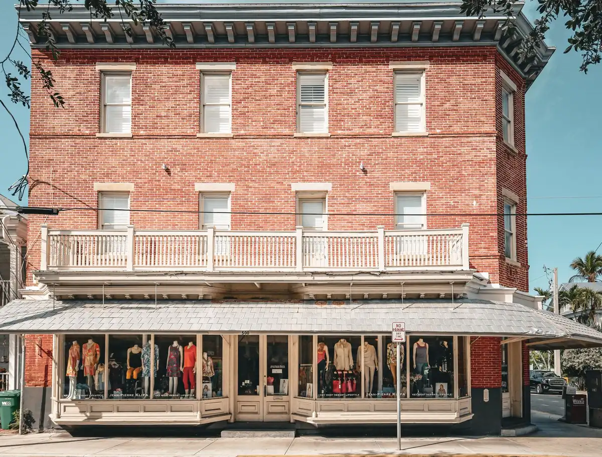 A weathered wooden Cracker Barrel store exterior with the restored original "Old Timer" barrel logo prominently displayed, surrounded by loyal customers entering the restaurant, conveying brand heritage and customer connection.