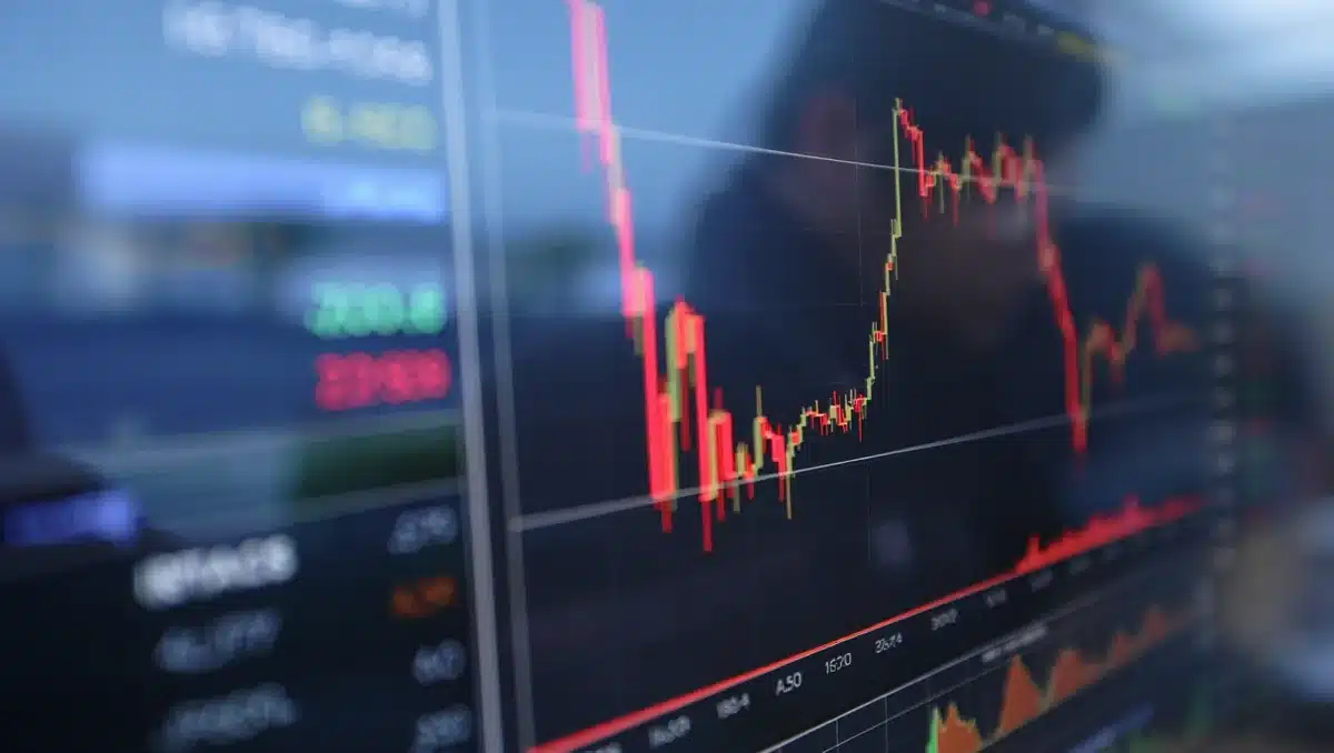 Stock trading screen showing red-colored price charts, candlestick patterns declining sharply, financial data streaming across display, tension | stock market decline chart
