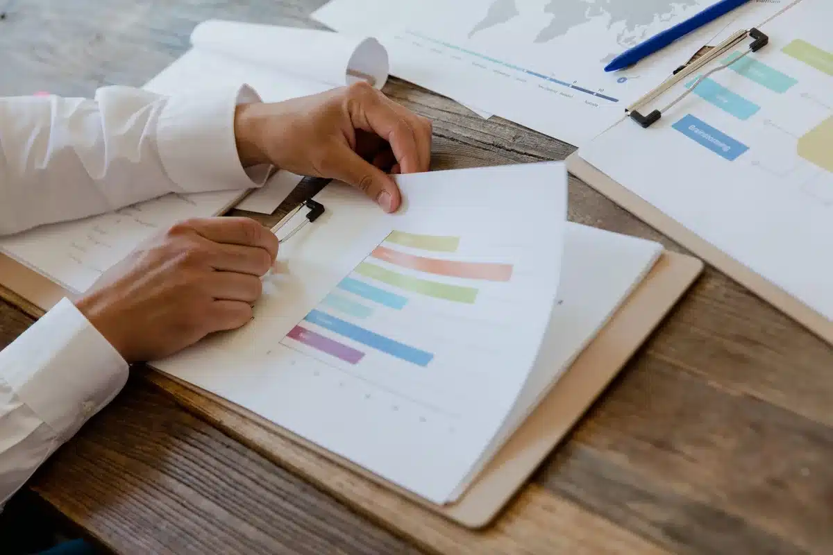 A formal institutional investigation report document lying on a desk, pages spread open with redacted text visible, a pen resting beside it, natural light casting shadows across the papers, institutional accountability