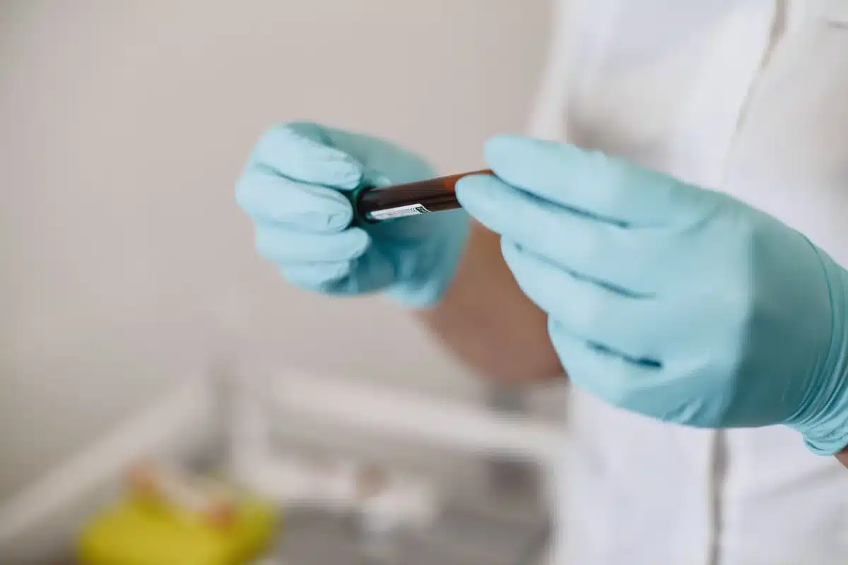 A close-up of a blood test sample vial and lab analysis equipment, symbolizing health monitoring and lead exposure research.