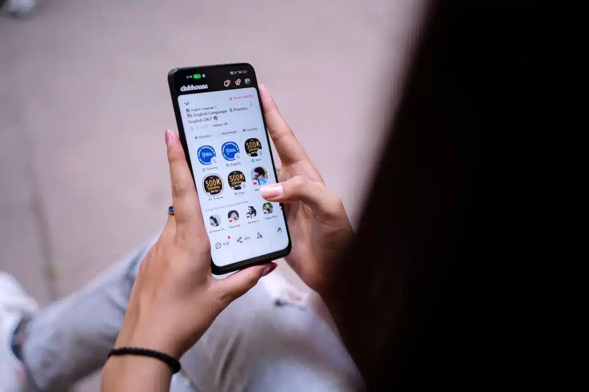 Scrolling social media feed with comments and reactions visible, phones or screens glowing in darkness, text partially visible