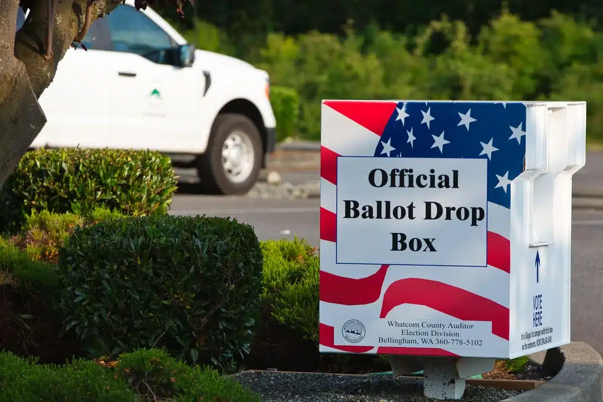 Early voting location with citizens lined up, ballot boxes visible, official election materials and signage, civic participation and democratic process
