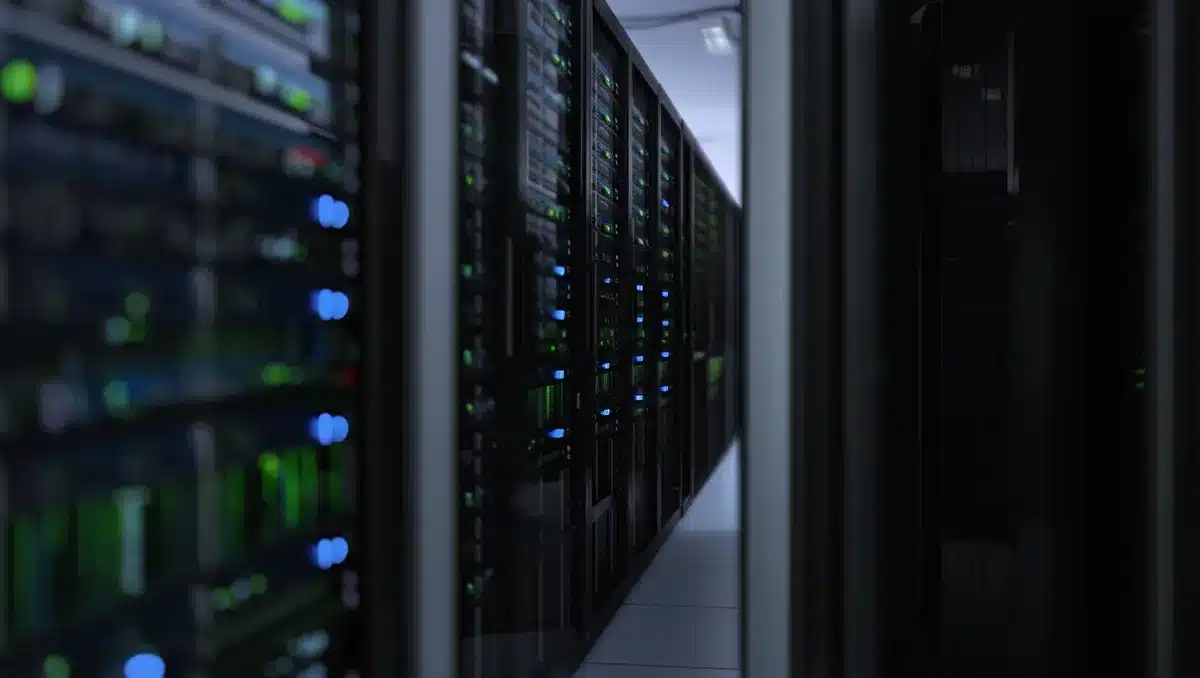 A data center corridor with rows of server racks illuminated by blue and green indicator lights | data center infrastructure