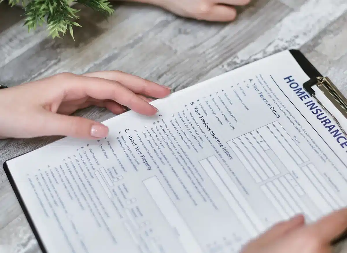 A close-up of campaign literature and policy documents on a table, showing "Affordability" messaging, with hands pointing to specific cost-reduction proposals and a calculator visible nearby.