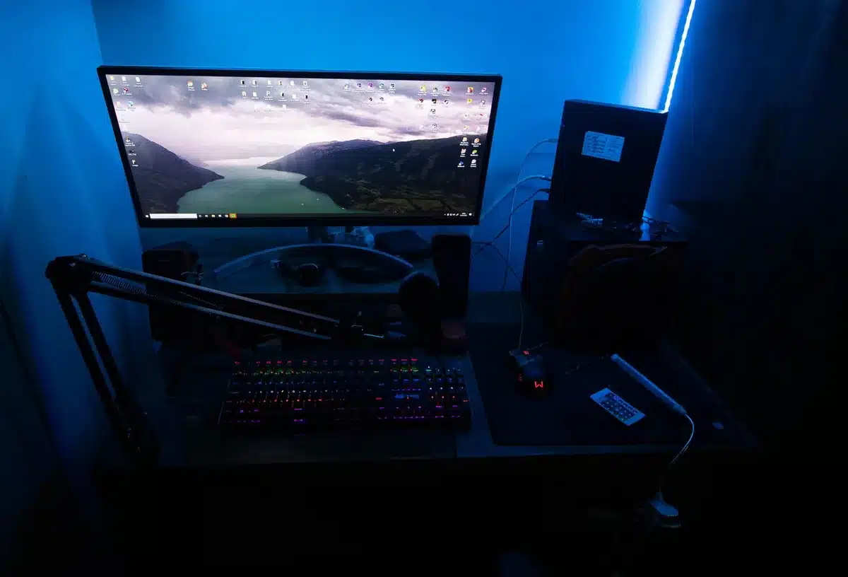 A Twitch streamer's setup with a glowing computer monitor reflecting off a darkened face in silhouette, the chat scrolling rapidly in the background, intimate and isolated