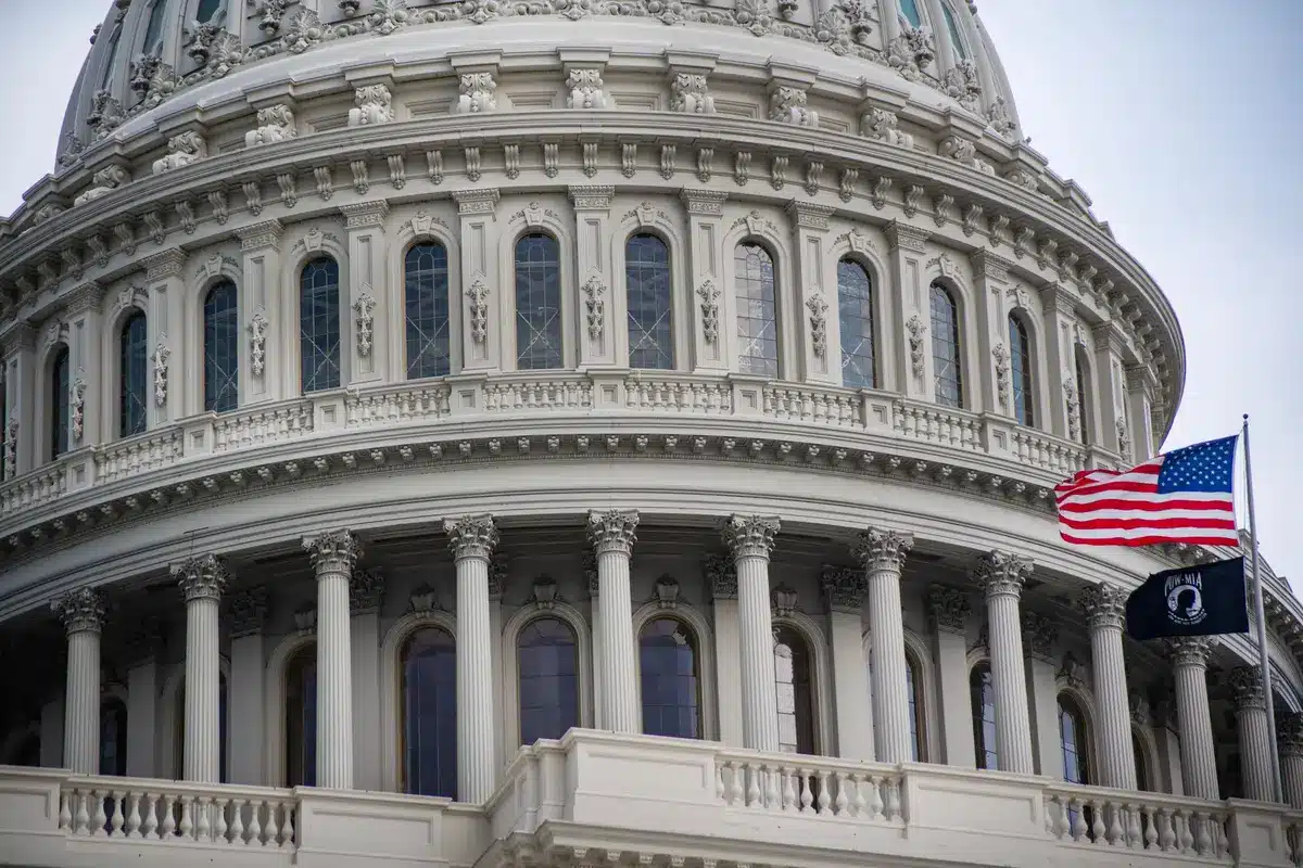 A federal government building with marble columns and an American flag, representing legislative action on postal service oversight