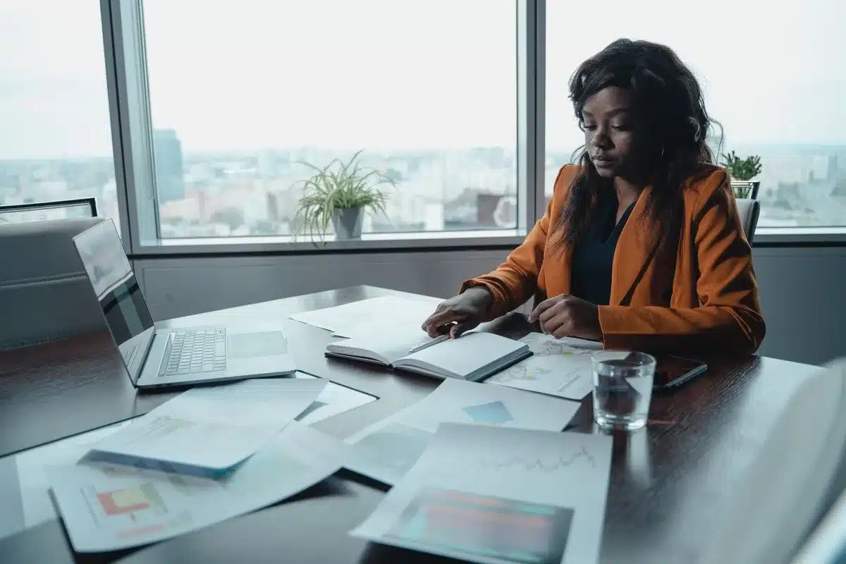 A healthcare insurance executive in an office reviewing financial charts on a computer screen showing declining profit margins and rising medical costs