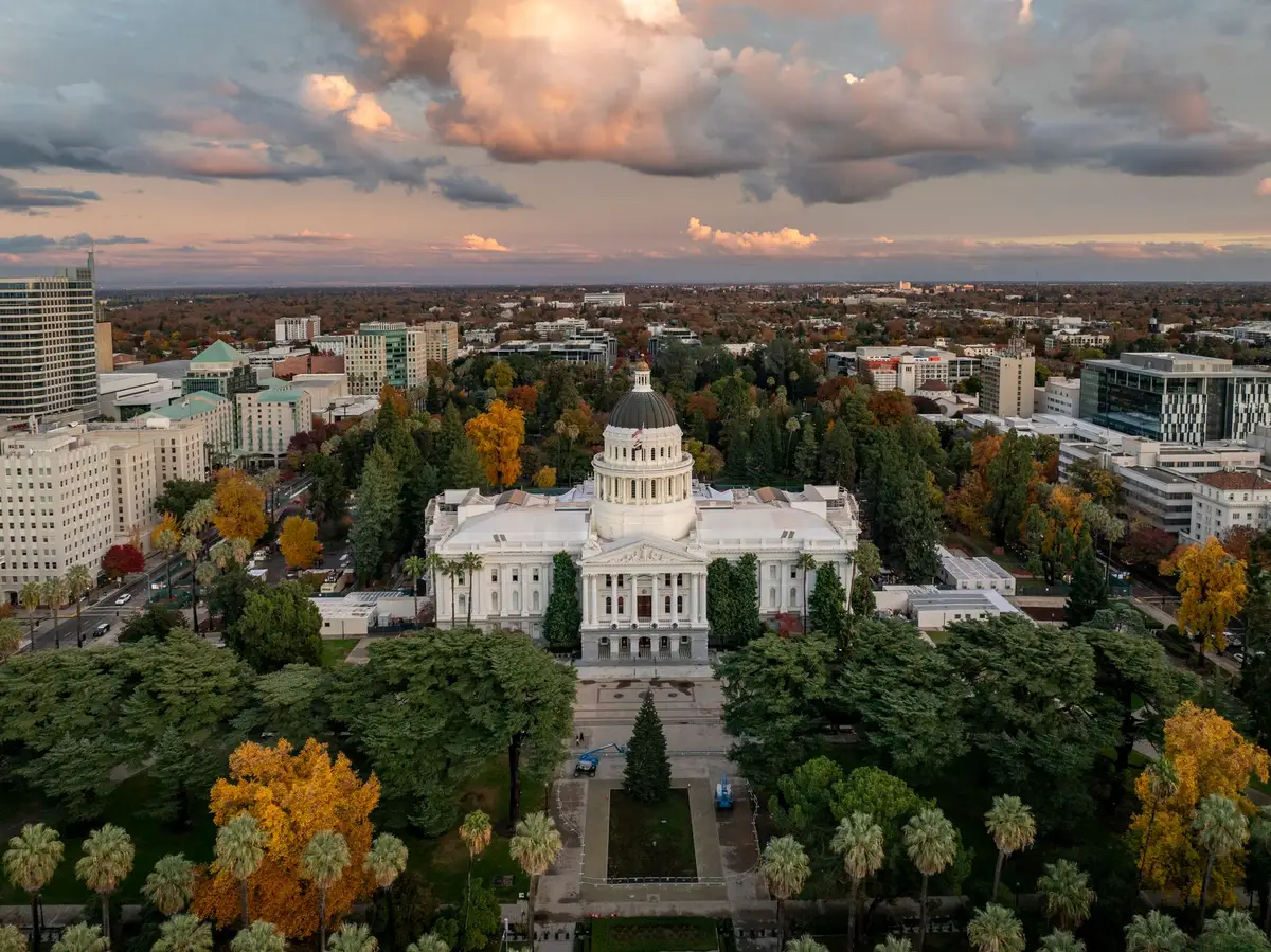 An empty state capitol building corridor or legislative chamber, dim lighting, a single vacant seat in focus, suggesting absence or a shift in political representation.
