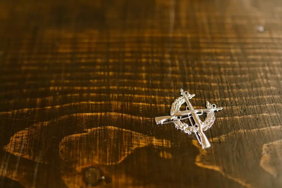 A portrait-style photograph of formal provincial honors or ceremonial regalia on a dark wooden desk, soft spotlight catching the detail, representing decades of public service