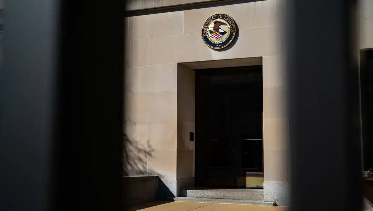 Empty Justice Department building entrance with official seal, daytime lighting | DOJ building exterior