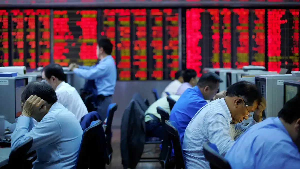 Stock market trading floor with red electronic displays showing sharp index declines, traders at workstations amid market volatility and concern | stock market crash trading floor