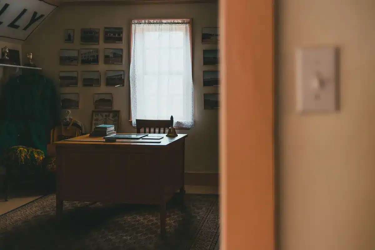 A quiet Senate office with family photographs on the desk, including a framed photo of two siblings, natural daylight casting long shadows, the space conveying duty and family bonds