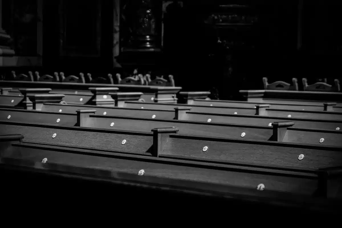 An empty judicial bench in a courtroom with carved wooden details and the seal of New York, sunlight streaming through high windows, emphasizing institutional formality and the weight of judicial appointments.