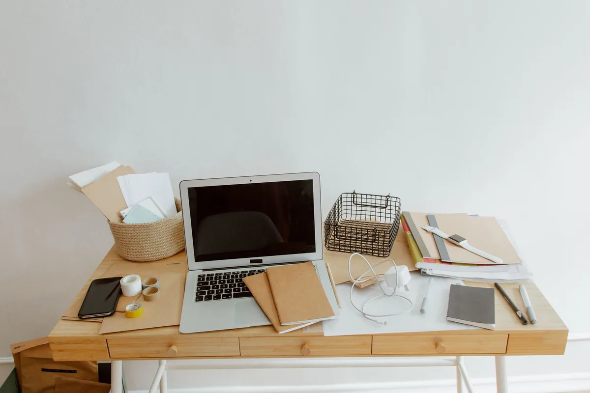 An elegant home office or study with vintage home management books, a laptop, and handwritten notes about home organization, evoking Martha Stewart's decades of expertise.