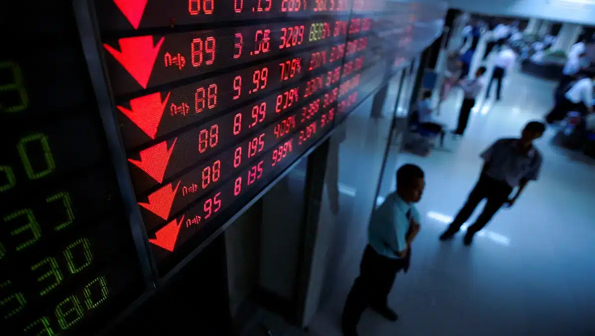 Stock market display board showing red arrows and percentage declines, with focus on semiconductor sector, muted lighting and sharp contrast | market decline visualization