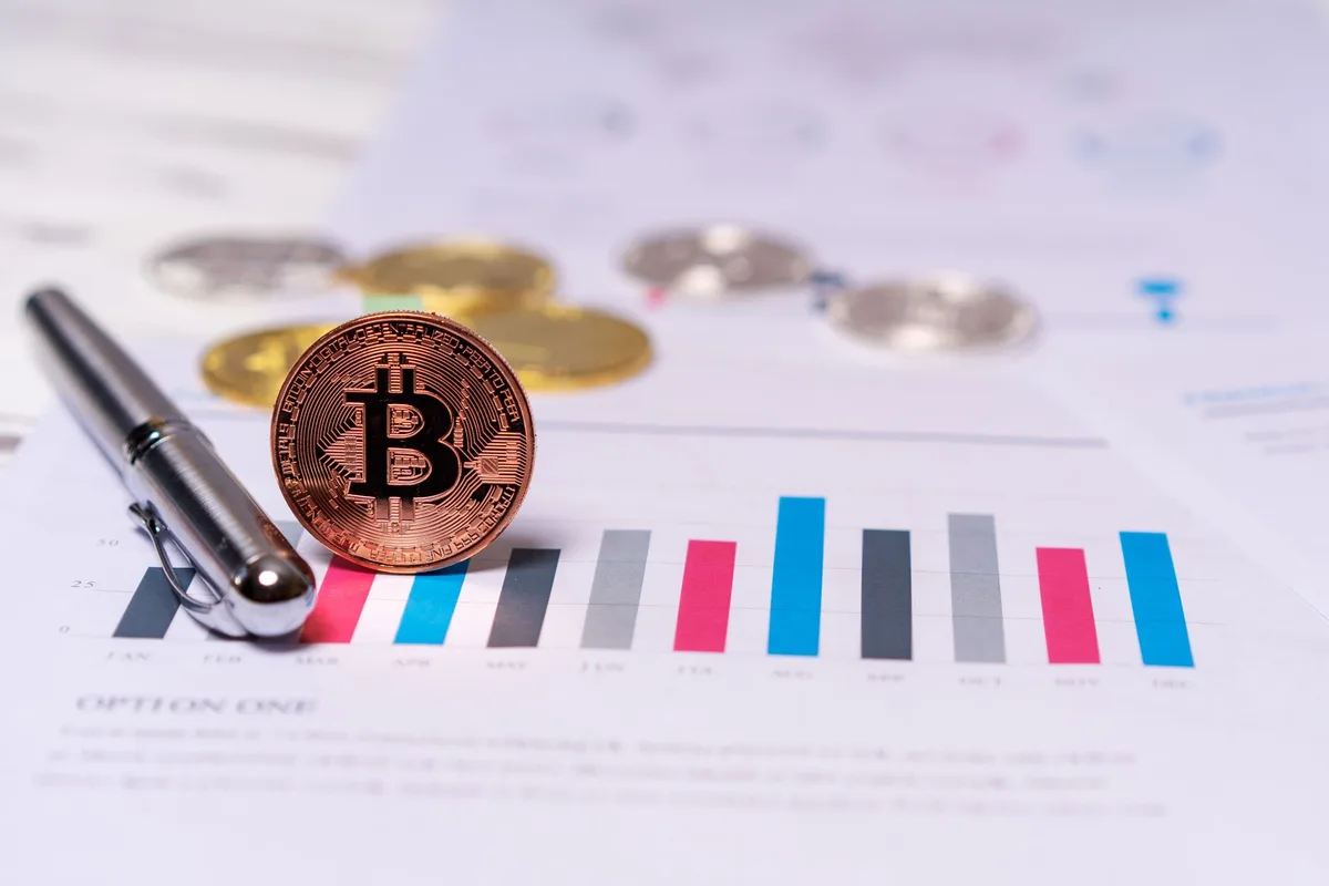 A financial data screen showing cryptocurrency market charts and holdings data in real-time, with declining price indicators and Bitcoin ticker symbols visible