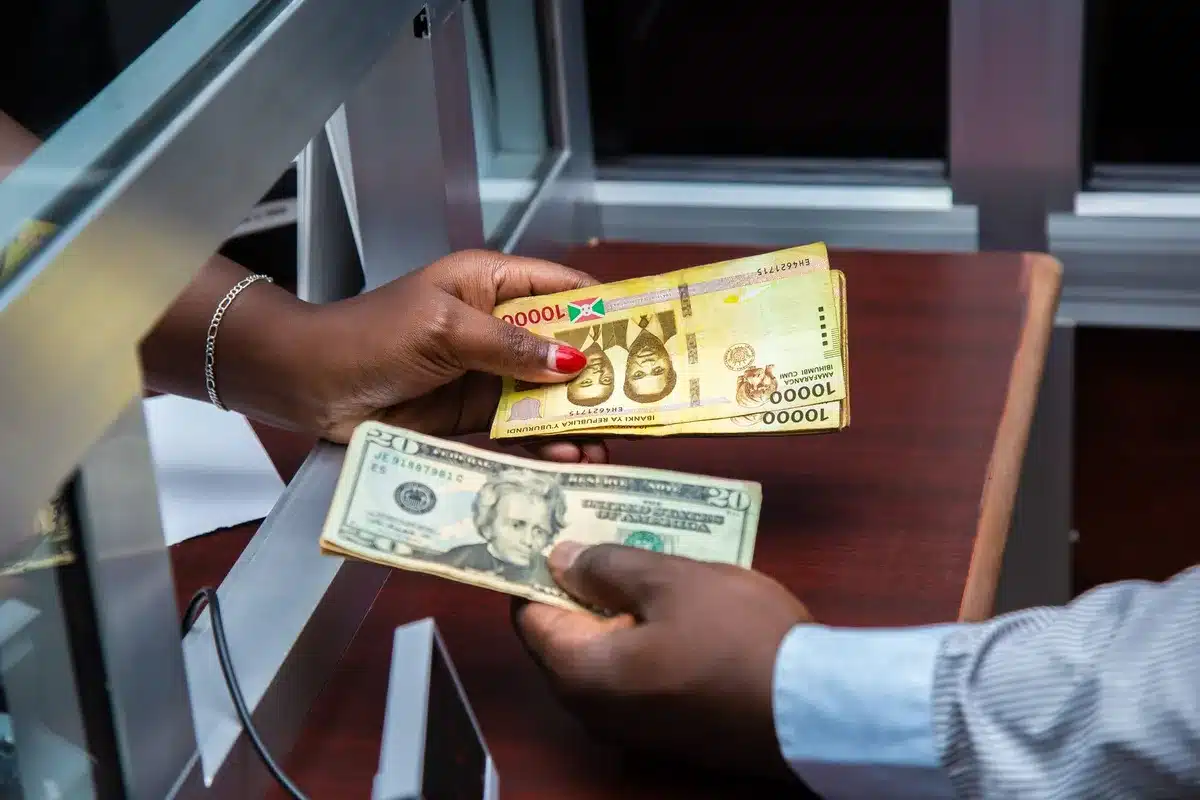 Central Bank of Nigeria trading floor with multiple screens displaying exchange rates and currency data, traders monitoring real-time market movements, a managed float environment with tight spreads visible on displays