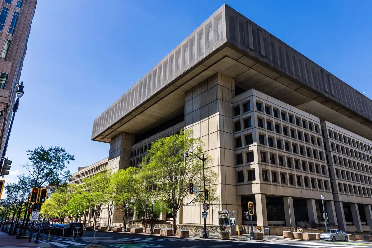 Pentagon building exterior with American flag, military insignia visible, modern defense architecture, professional government setting