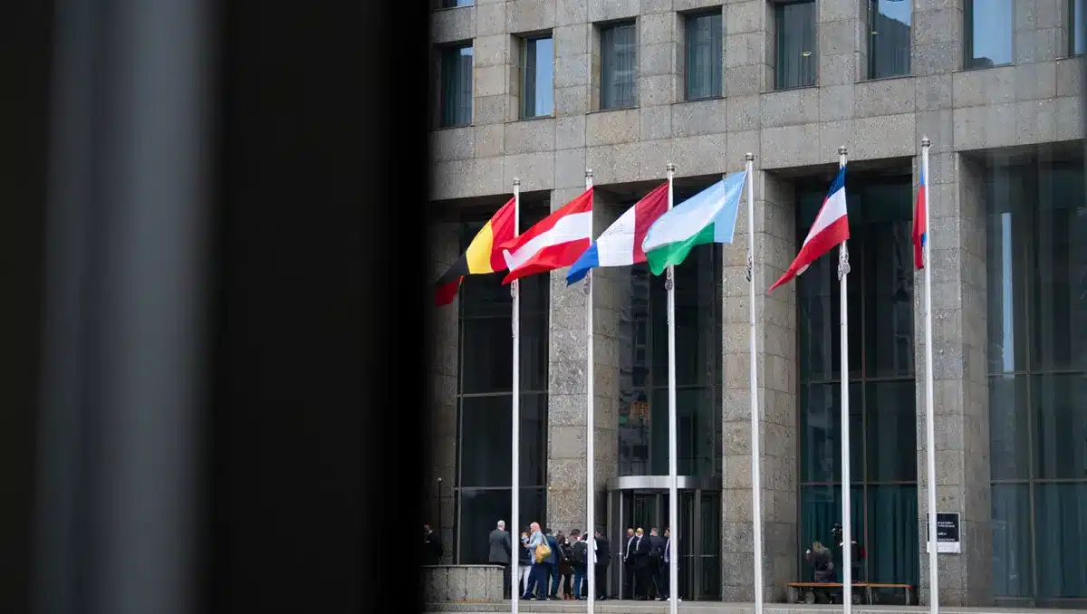 A modern government building with flags, representing international cooperation between law enforcement agencies combating cybercrime | government cooperation meeting