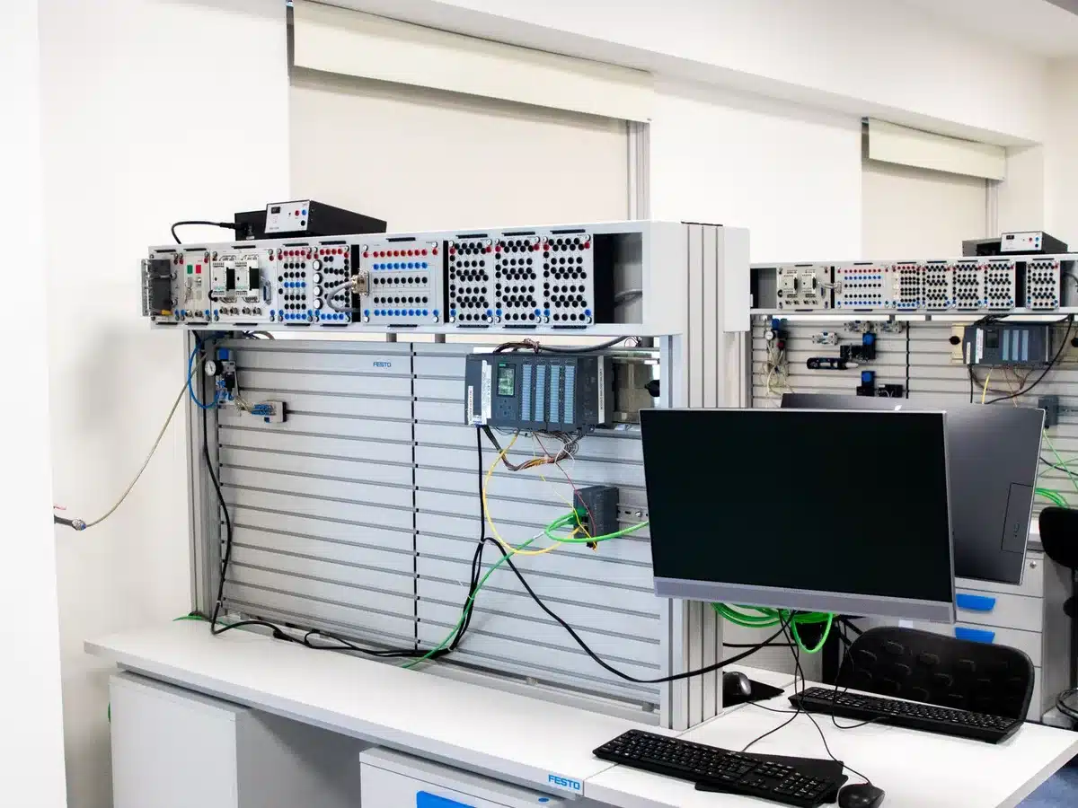 A control room with technicians monitoring multiple screens displaying grid data and real-time electricity demand metrics in dim lighting