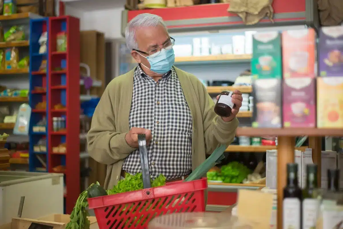 A parent checking a food label in a kitchen pantry, hands holding a pouch up to light, concerned expression suggested by body language