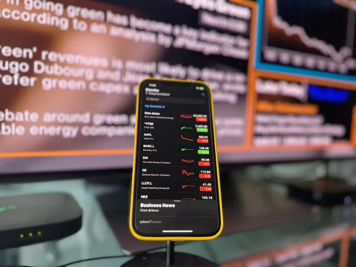 A sleek modern trading floor with multiple monitors displaying stock tickers and index data, traders working at desks, green and blue digital displays showing market activity, a sense of coordinated financial activity