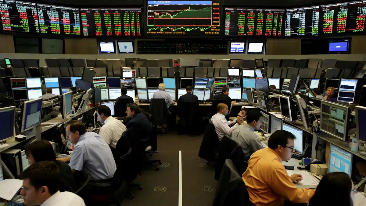 Stock market trading floor with multiple screens displaying financial data and price charts, traders monitoring positions, real-time data streams | financial markets trading