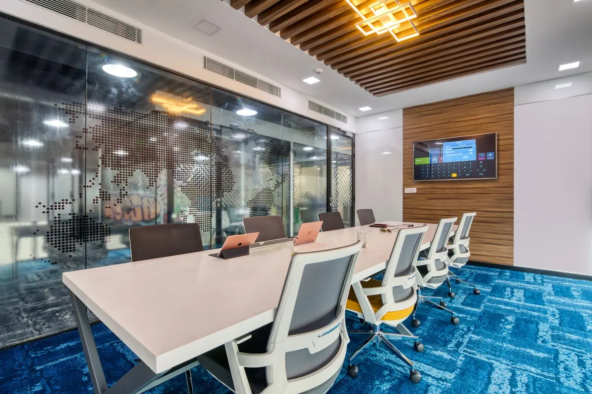 A minimalist corporate boardroom with an empty CEO chair at the head of a glass table, soft blue ambient light illuminating the space, a single glowing monitor displaying abstract data streams in the background, no people visible