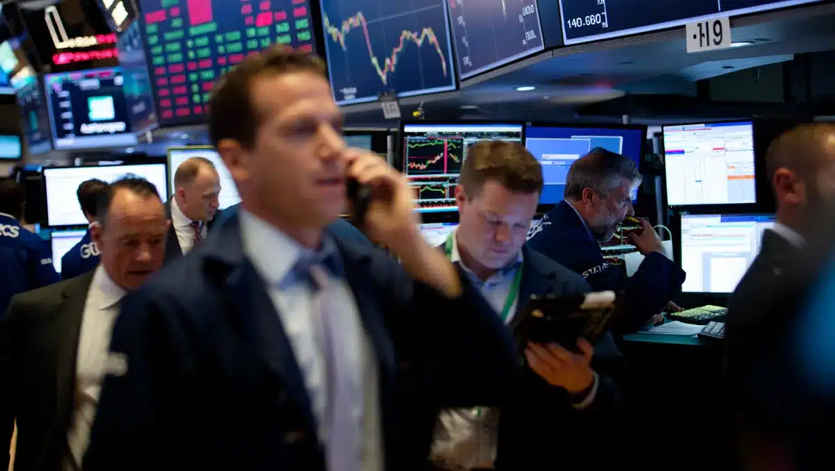 Stock market trading floor with multiple screens displaying red numbers and declining charts, traders in motion, urgent energy in a financial center | stock market trading floor