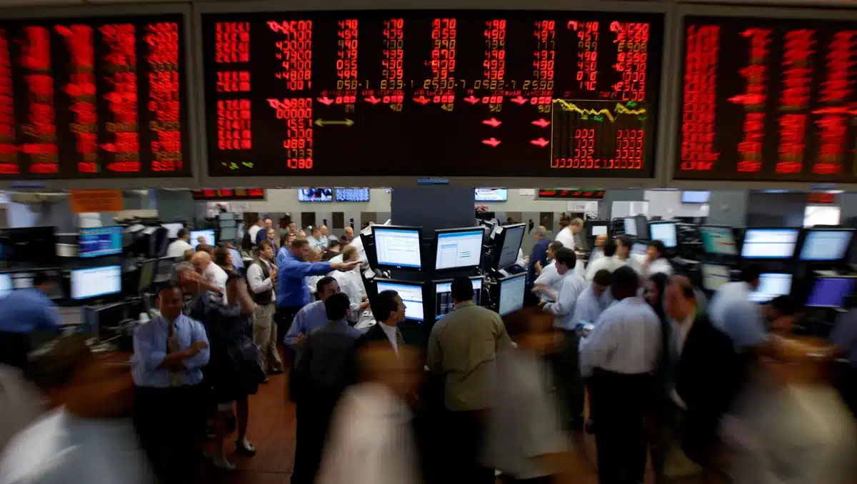 Stock market trading floor with digital screens displaying red semiconductor stock prices and downward arrows, traders in motion amid the decline | semiconductor stock market decline