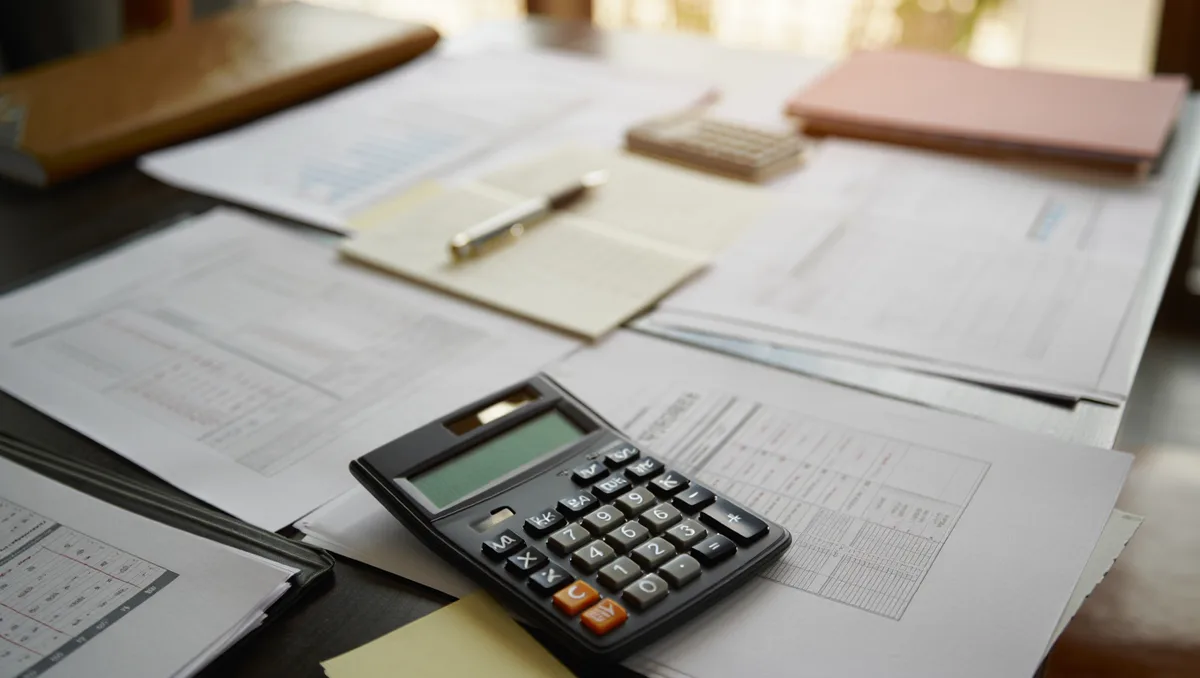 Corporate finance documents and quarterly earnings reports spread on a desk, with calculator and pen, symbolizing investor scrutiny of AI spending | corporate earnings analysis