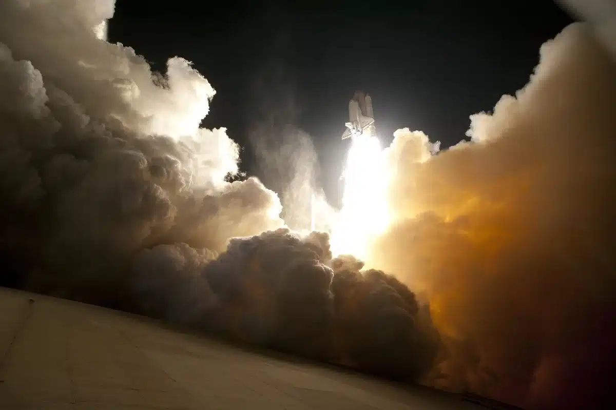A Starship rocket ascending through layers of atmosphere, payload bay doors opening as satellites begin their deployment sequence, the curvature of Earth visible in the background, flames and exhaust creating a dramatic contrast