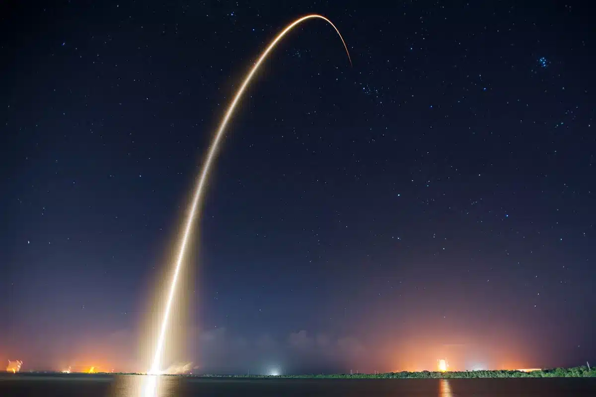 A Falcon 9 rocket on the launch pad at Vandenberg Space Force Base, fully fueled and ready for liftoff, bathed in pre-dawn or evening light, the white booster standing tall against a California sky.