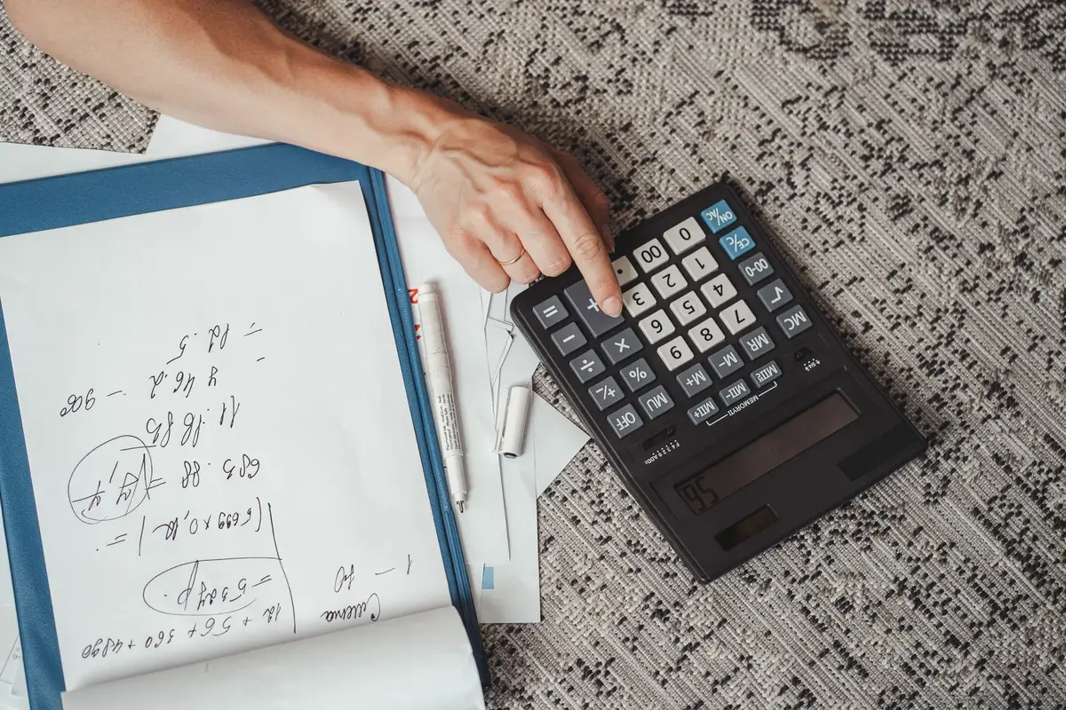 A stack of student loan documents and financial statements on a desk, with a calculator and pen nearby, showing the complexity of loan repayment options