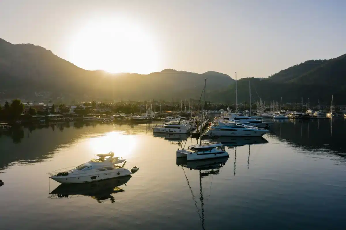 Couple on a luxury yacht in Mediterranean waters, golden sunlight on blue sea, intimate moment during summer getaway, joy and romance
