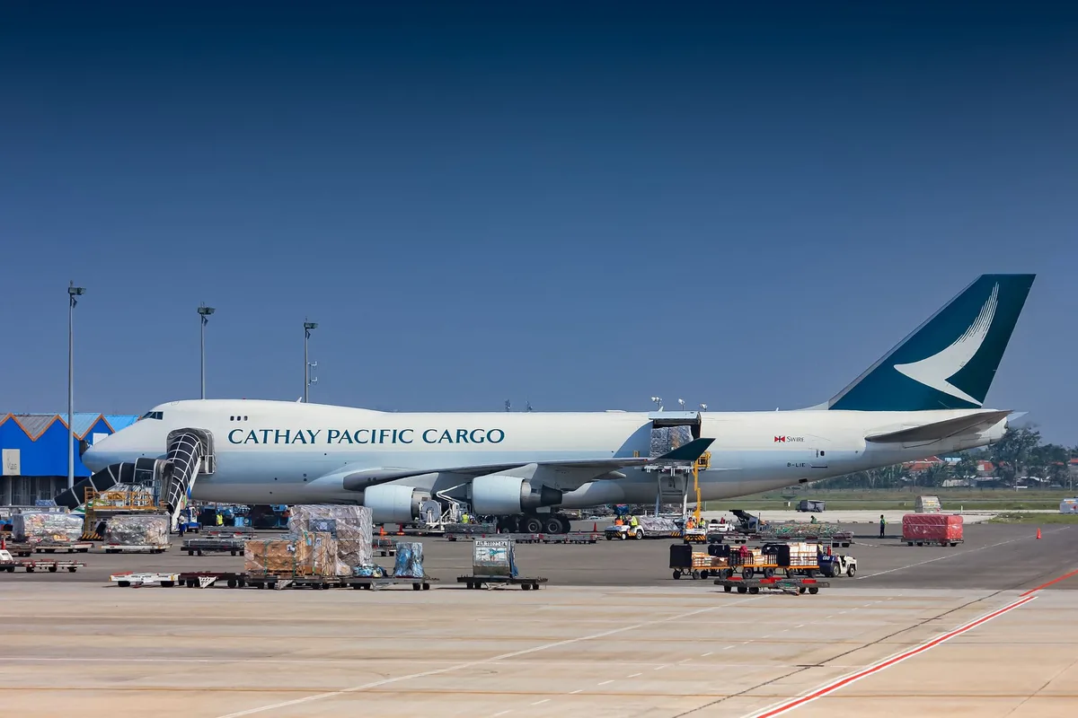A modern Boeing 747 aircraft in a hangar with technicians and equipment around it, showing the scale and complexity of the jet's interior modifications.