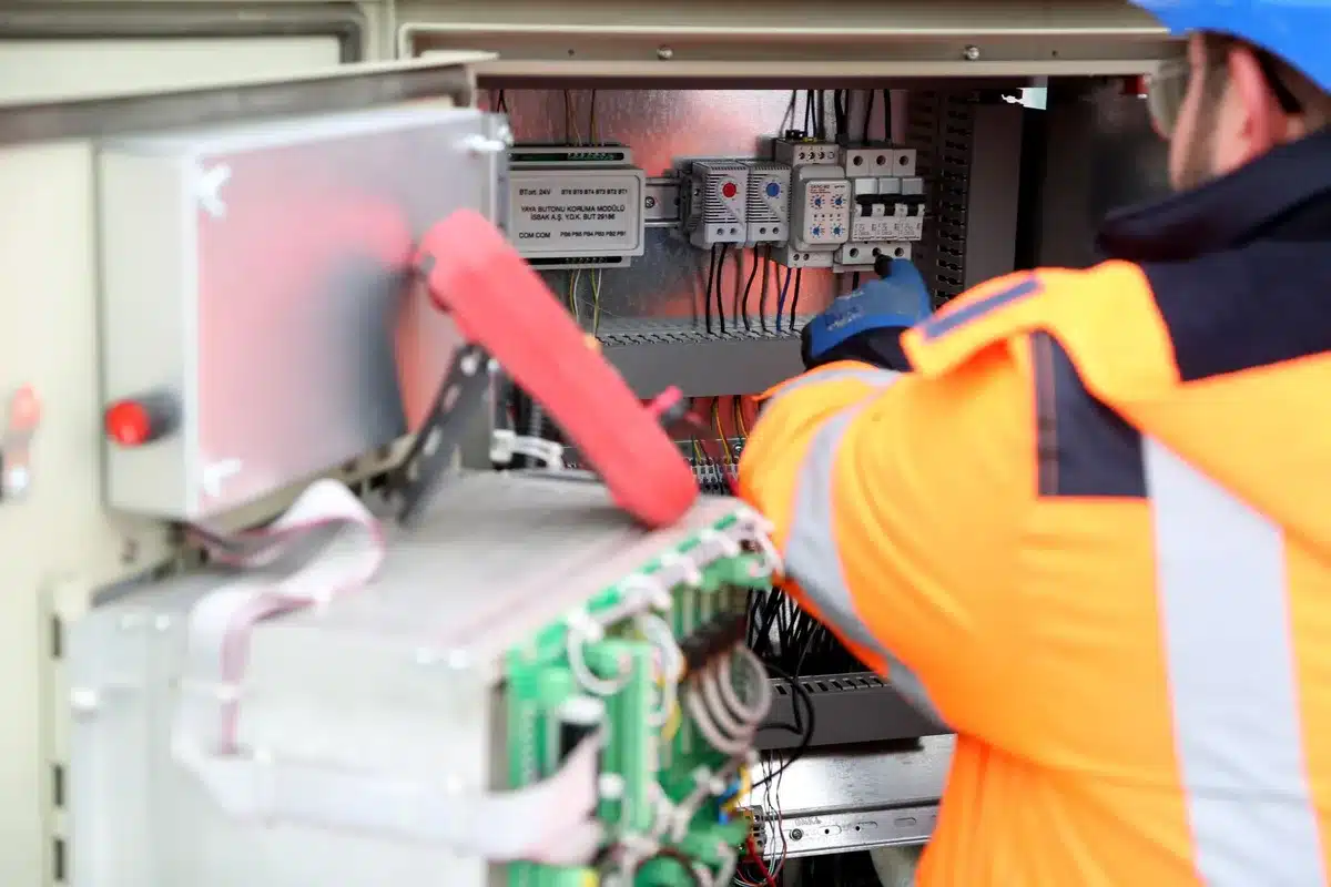 A utility control room with technicians monitoring grid systems on multiple screens, data streams and power flow visualizations glowing on the displays, a sense of complex infrastructure management and oversight.
