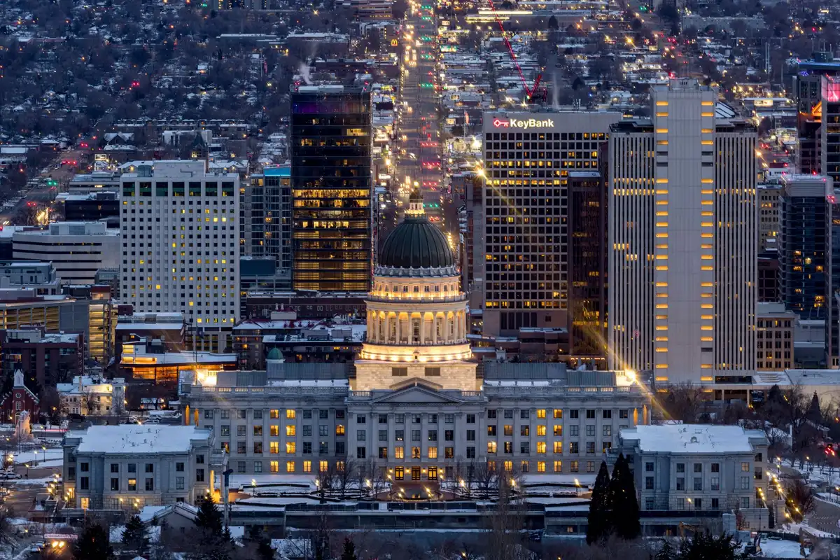 A split-screen comparison: left side shows a state capitol building facade, right side shows the Supreme Court building exterior, clean architectural lines, no people, symbolizing the competing jurisdictions