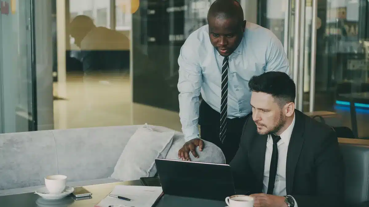 A modern corporate office setting with multiple technology screens displaying data analytics and customer insights dashboards, representing digital transformation leadership and strategic technology direction.