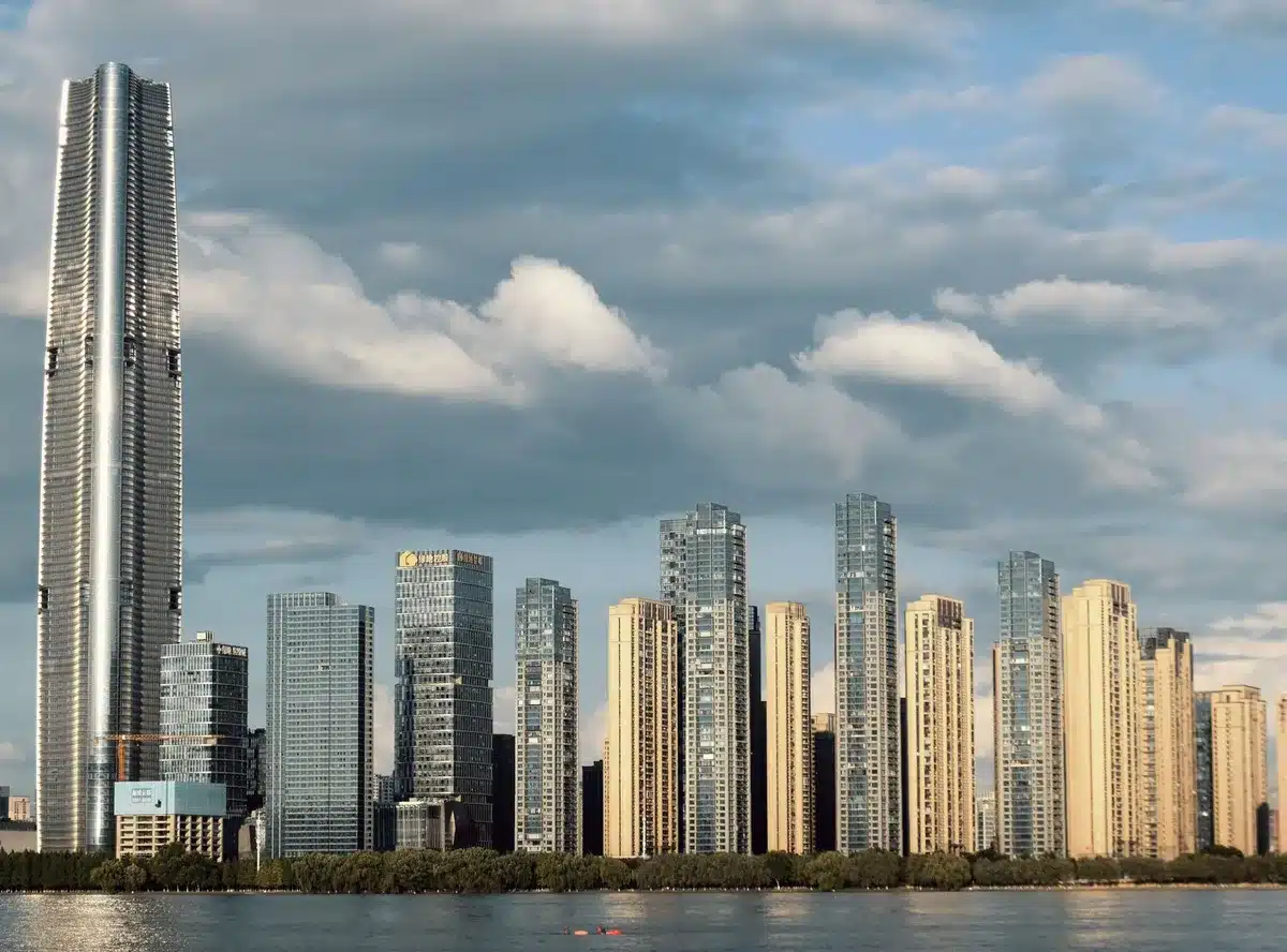 Multiple skyscrapers of varying heights arranged in a comparative lineup, glass and steel structures against a gradient sky, architectural details visible at different scales