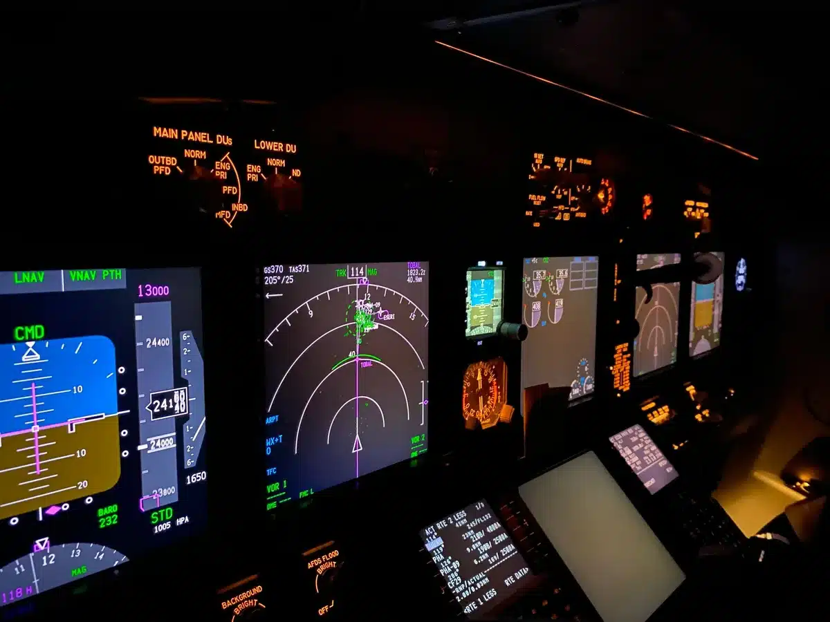 An aircraft flight control panel with warning lights illuminated, showing hydraulic pressure gauges and system indicators in red alert