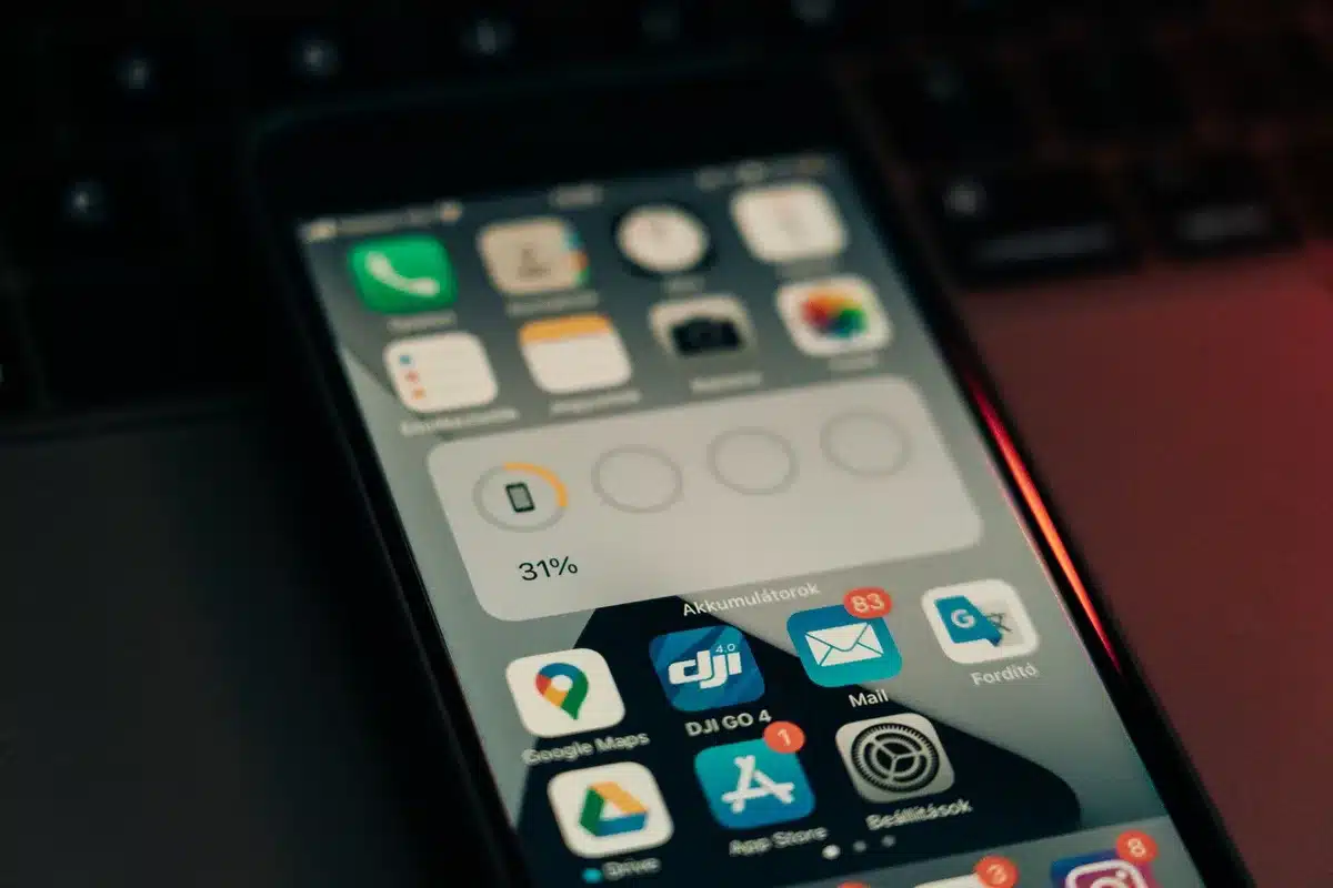 A close-up of a mobile phone app interface showing booking confirmations and reservation details with a check mark, warm lighting illuminating the screen
